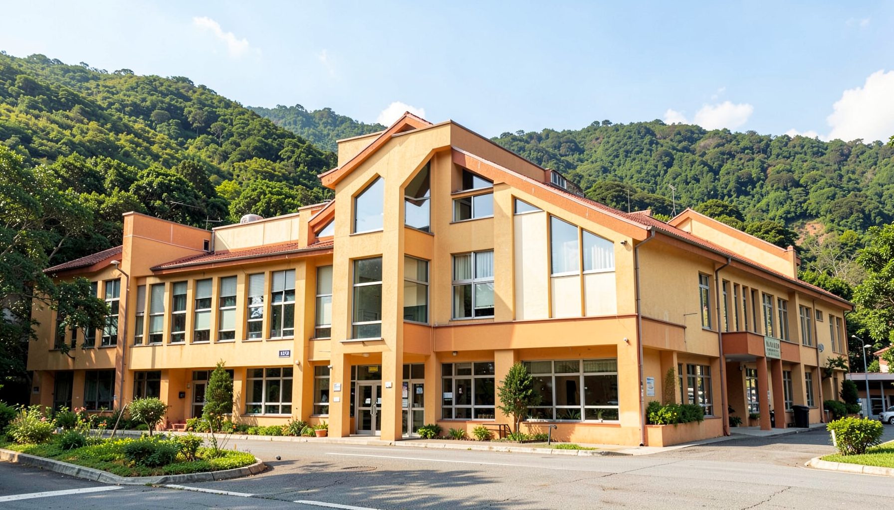 Warm-toned exterior view of a hospital building nestled against green hills under a bright sky
